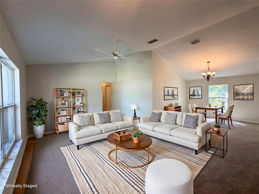 A living room with two white sofas, a round coffee table, and a dining area — 517 BAHIA CIRCLE RUN, OCALA, FL