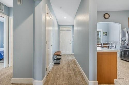 A hallway with light blue walls, wood-look tile flooring, and a white door — 1410 CELEBRATION AVENUE UNIT 407, CELEBRATION, FL