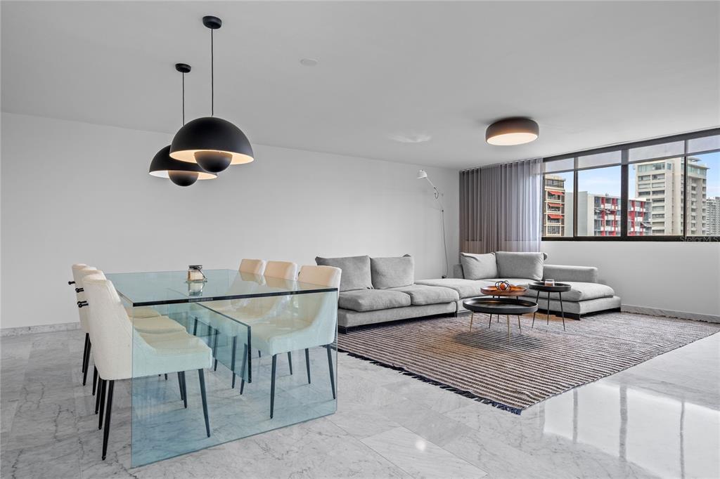 A modern living and dining area features a glass table, gray sofa, and marble flooring — 1223 LUCHETTI STREET UNIT 7S, SAN JUAN, PR