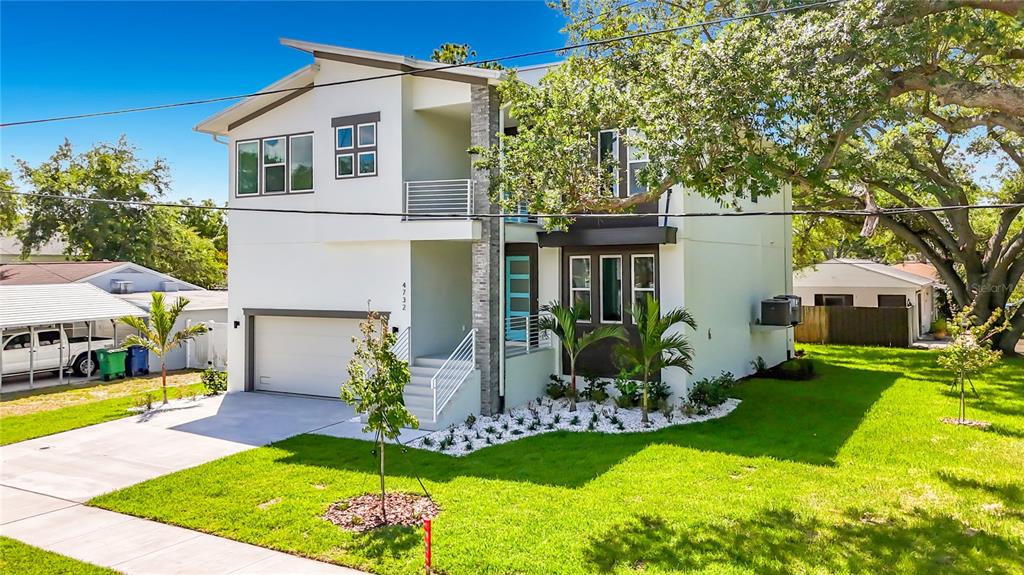 A modern two-story house with a white exterior, attached garage, and a landscaped front yard — 4732 W WALLCRAFT AVENUE, TAMPA, FL