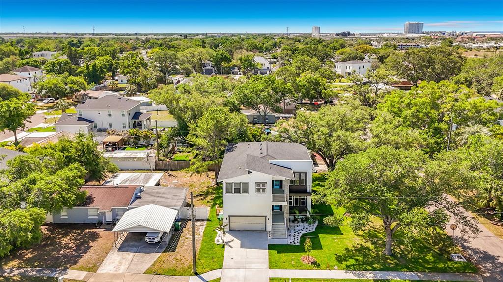 An aerial view shows a modern two-story house with a garage next to an older home — 4732 W WALLCRAFT AVENUE, TAMPA, FL