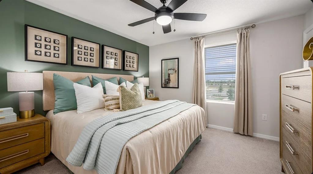 A bedroom features a green accent wall, a king bed, and a wooden dresser — 2770 ARMADALE DRIVE, MOUNT DORA, FL