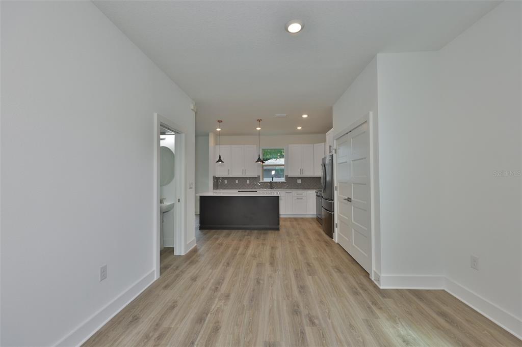 A kitchen with a dark island, white cabinets, and light wood flooring — 4171 56TH AVENUE N, ST PETERSBURG, FL