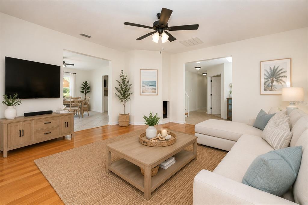 A living room features a sectional sofa, coffee table, media console, and hardwood flooring — 1636 TUSCALOOSA AVENUE, HOLLY HILL, FL