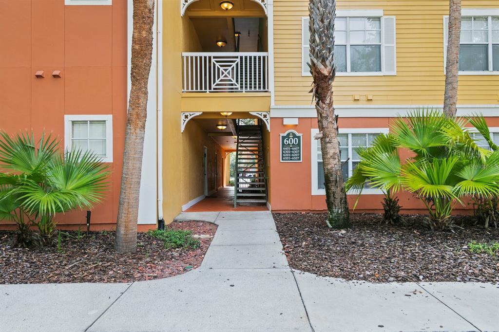 An exterior view of a multi-story apartment building with a staircase and palm trees — 4207 S DALE MABRY HIGHWAY UNIT 6107, TAMPA, FL