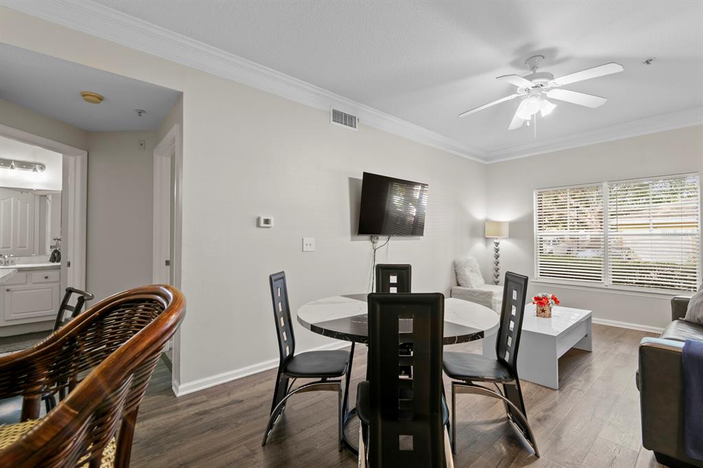 A dining area with a round table and chairs sits in an open-concept living space — 4207 S DALE MABRY HIGHWAY UNIT 6107, TAMPA, FL