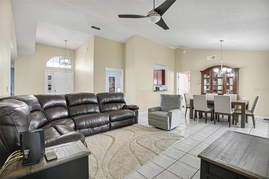 A living room with a large brown sectional, a gray recliner, and a dining area — 20123 MAXIM PARKWAY, ORLANDO, FL