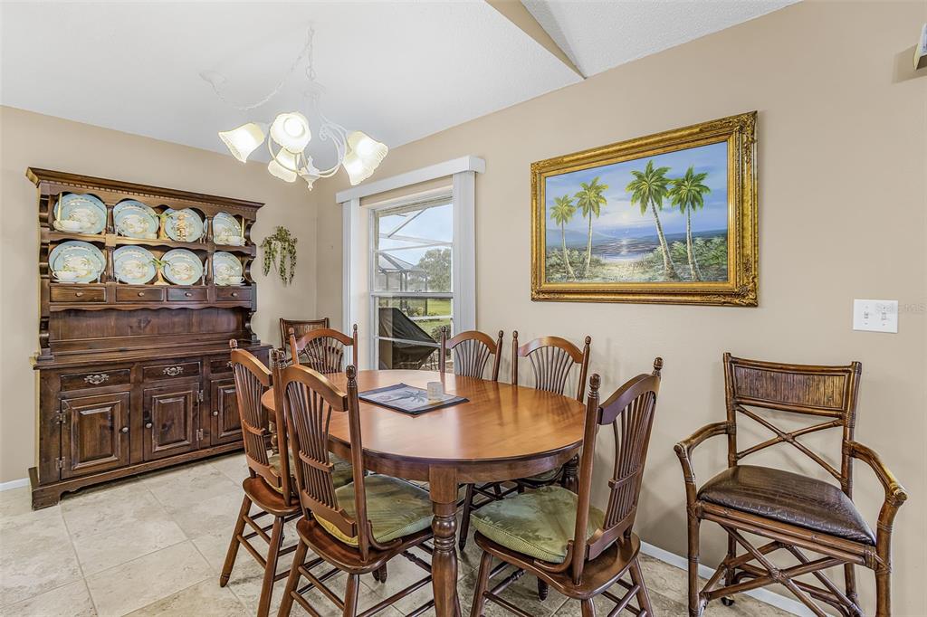 A dining room features a wooden hutch, an oval table with chairs, and a landscape painting — 26058 DEEP CREEK BOULEVARD, PUNTA GORDA, FL
