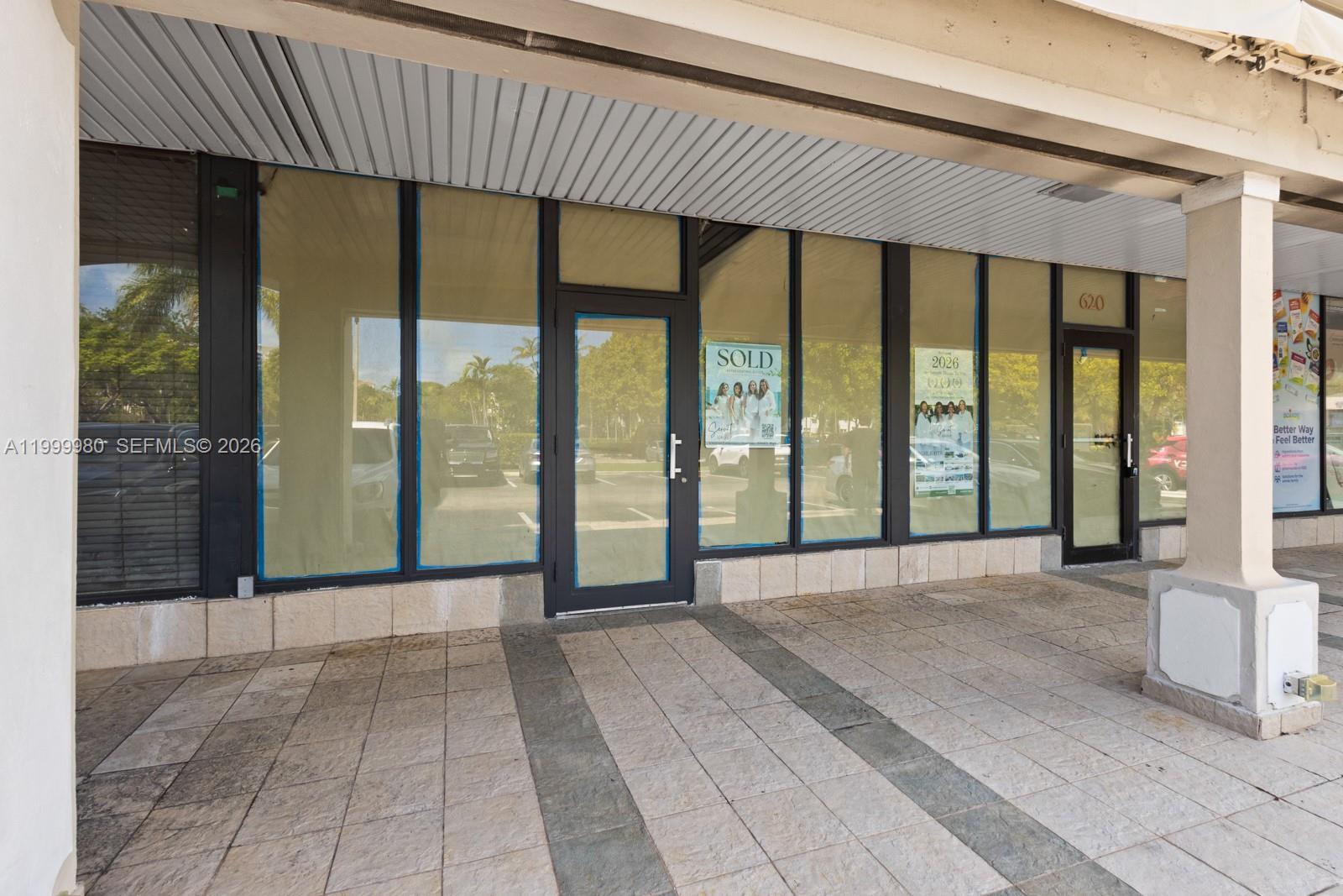 The exterior of a commercial storefront features large glass windows and a tiled walkway — 620 Crandon Blvd # 7, Key Biscayne FL 33149, KEY BISCAYNE, FL