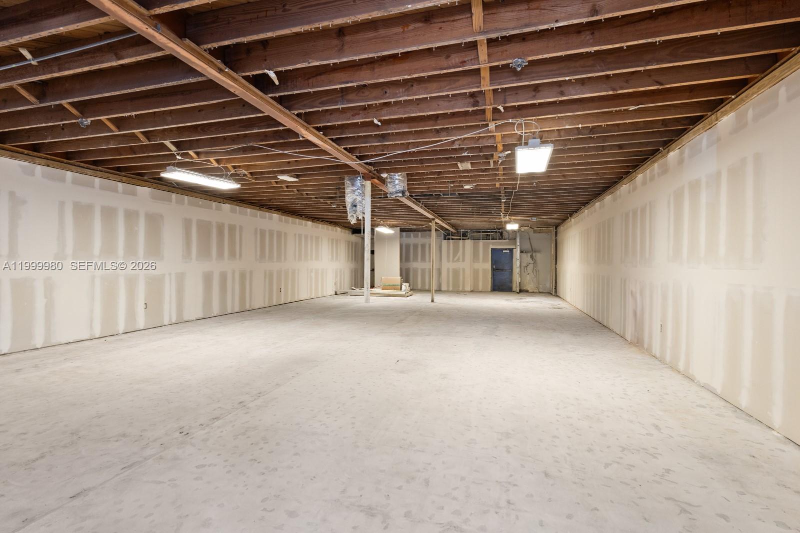 An unfinished commercial space features exposed wooden ceiling joists, drywall-taped walls, and concrete flooring — 620 Crandon Blvd # 7, Key Biscayne FL 33149, KEY BISCAYNE, FL