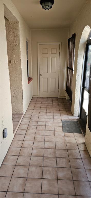 A covered entryway features tan tiled flooring, a light fixture, and a white interior door — 6468 BONNIE BAY CIRCLE N UNIT 0, PINELLAS PARK, FL