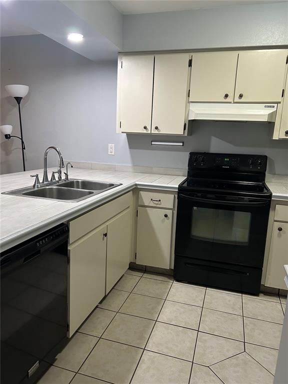 A kitchen features white cabinets, black appliances, a double sink, and tiled countertops and floors — 6468 BONNIE BAY CIRCLE N UNIT 0, PINELLAS PARK, FL
