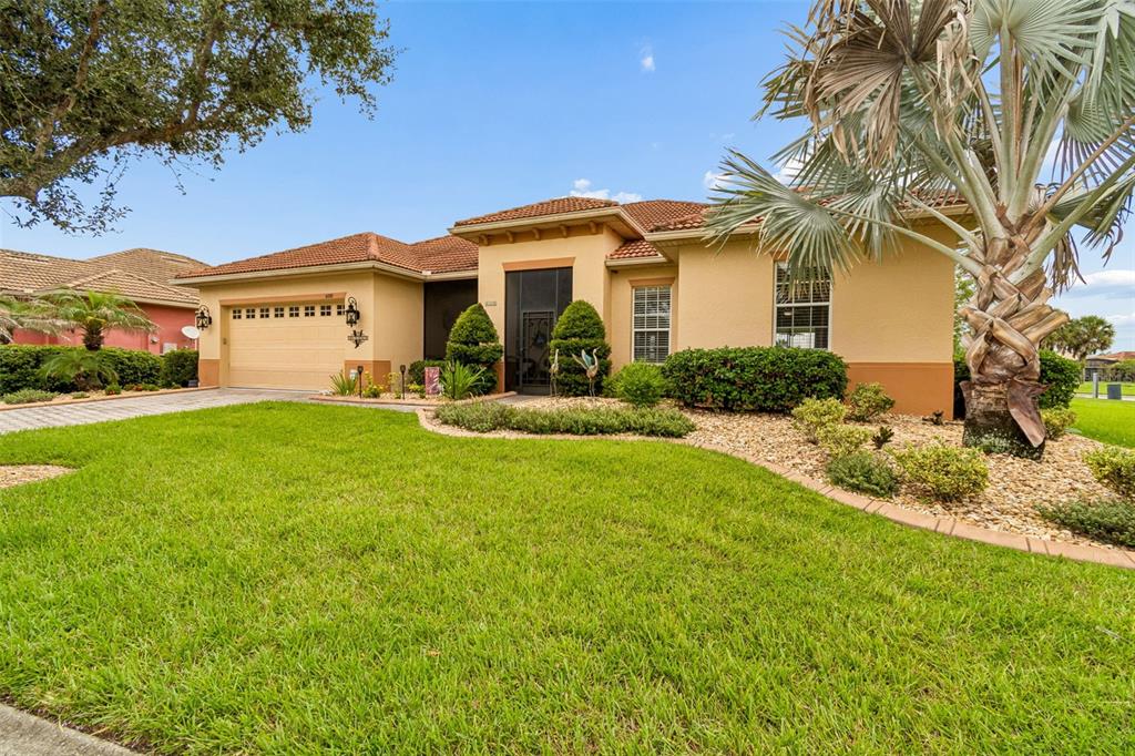 A single-story suburban house with a tan stucco exterior, tile roof, and a manicured lawn — 600 VOLTERRA BOULEVARD, POINCIANA, FL