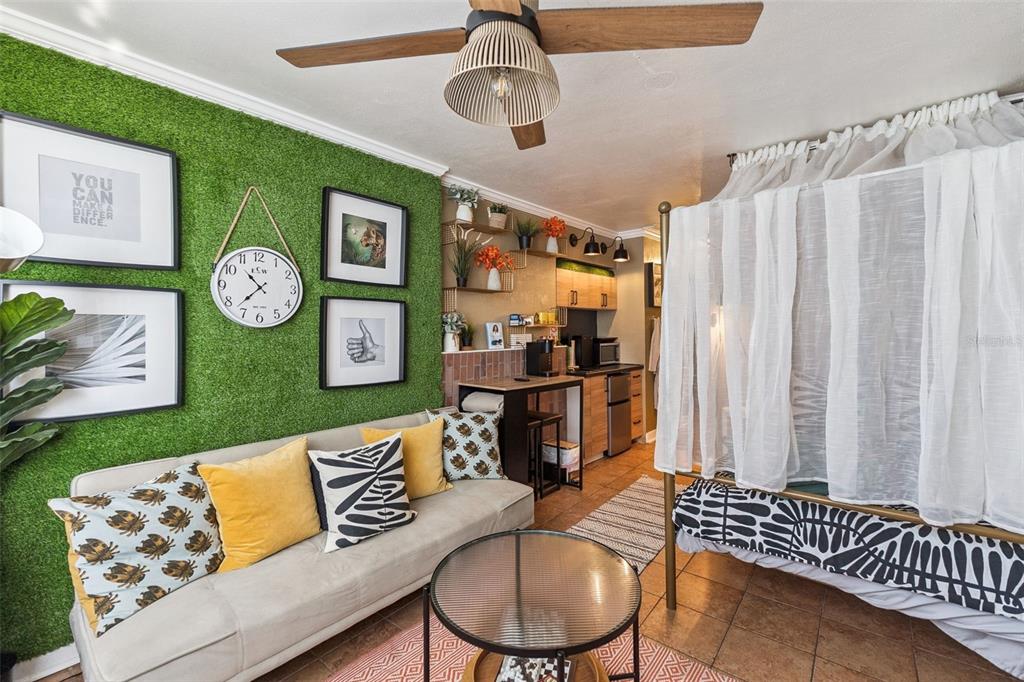 A studio apartment features a green grass wall, a sofa, and a curtained bed area — 1233 S ATLANTIC AVENUE UNIT 3140, DAYTONA BEACH, FL