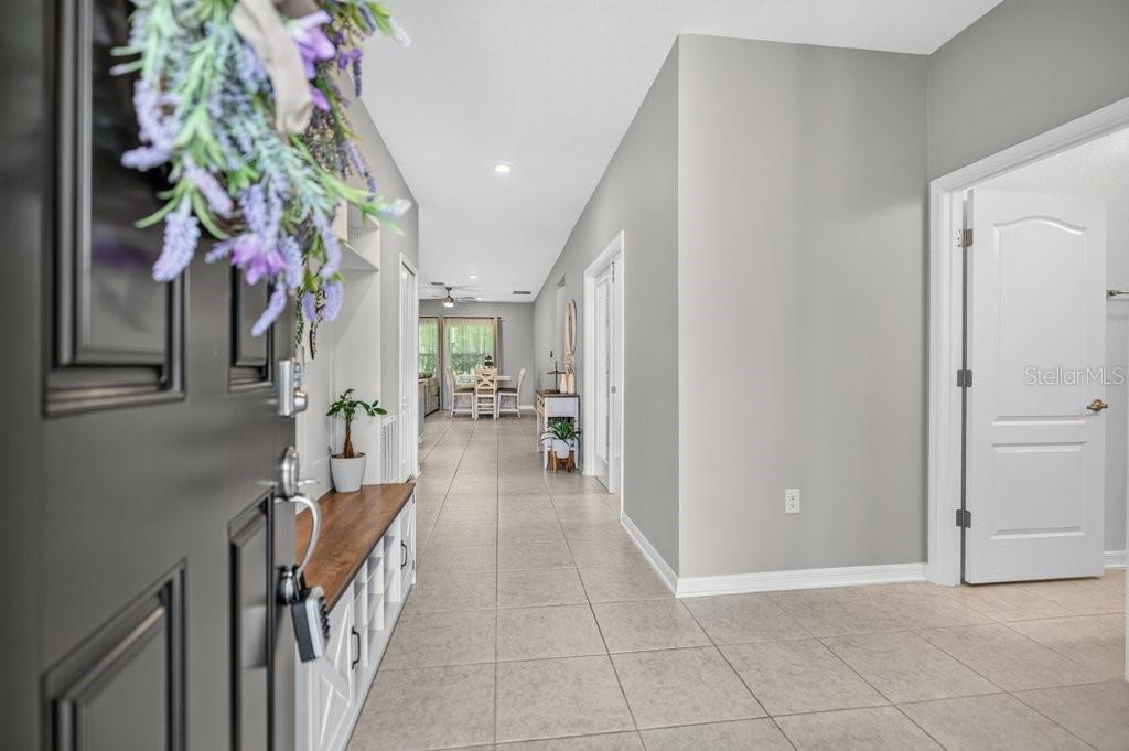 An entryway with tile flooring leads into a bright, open-concept living and dining area — 14 WOODWORTH DRIVE, PALM COAST, FL