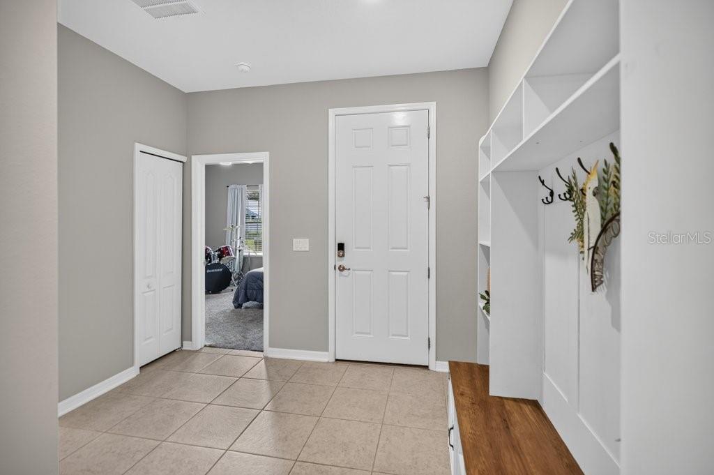 An entryway with tile flooring, a white door, a coat rack, and a closet — 14 WOODWORTH DRIVE, PALM COAST, FL