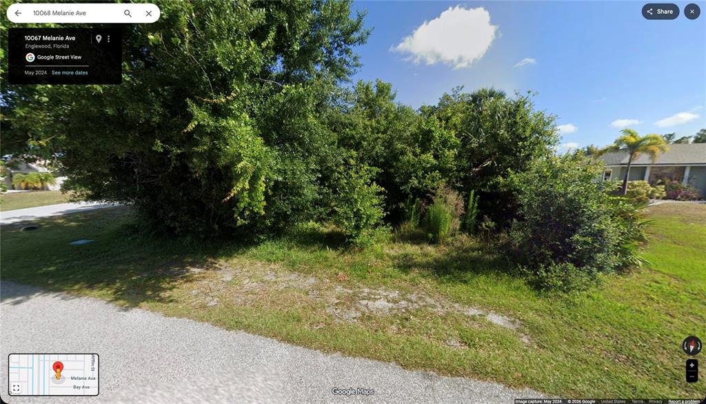 A densely wooded, undeveloped residential lot sits along a paved street — 10068 MELANIE AVENUE, ENGLEWOOD, FL