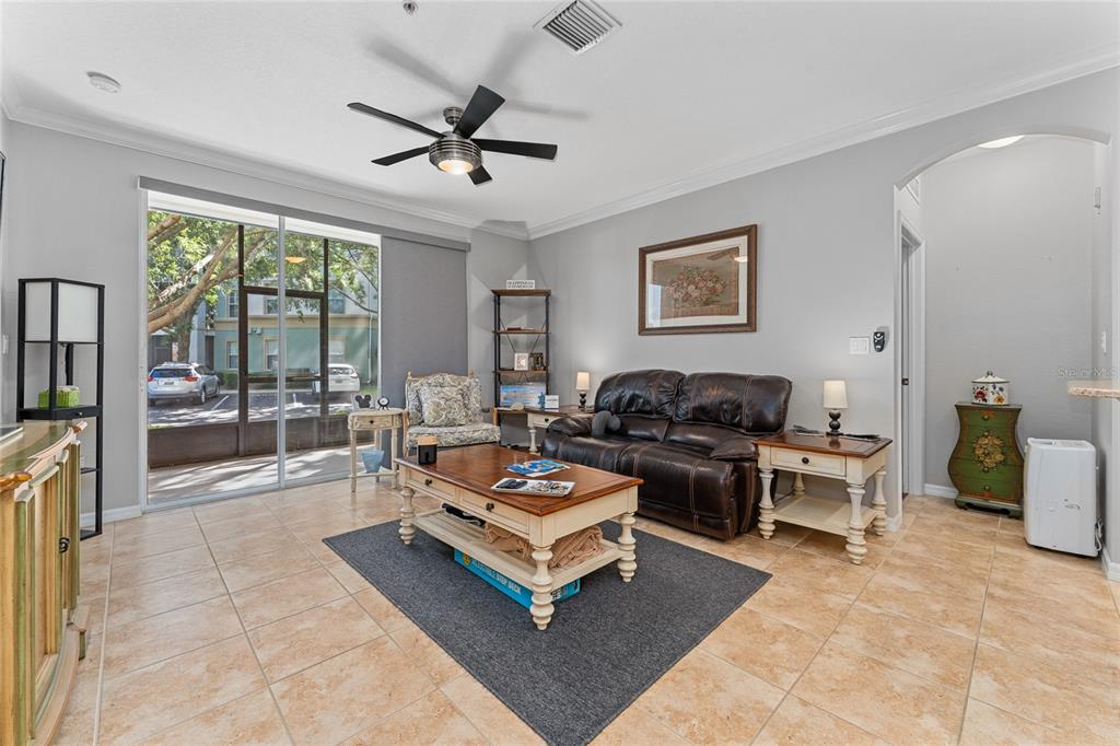 A living room features tile floors, a dark leather sofa, a coffee table, and sliding doors — 8180 BOAT HOOK LOOP UNIT 109, WINDERMERE, FL