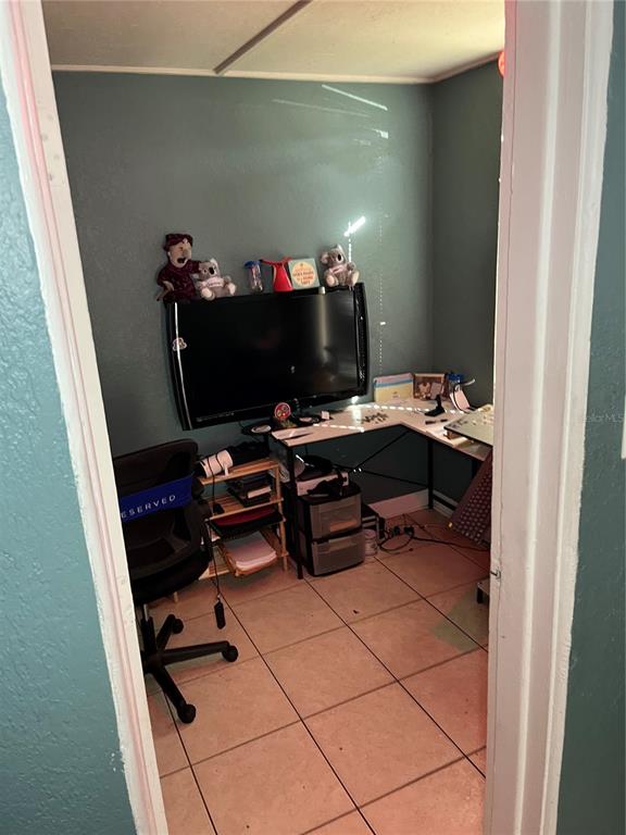 A small home office features a corner desk, a black office chair, and tiled flooring — 4325 LAKE LAWNE AVENUE, ORLANDO, FL