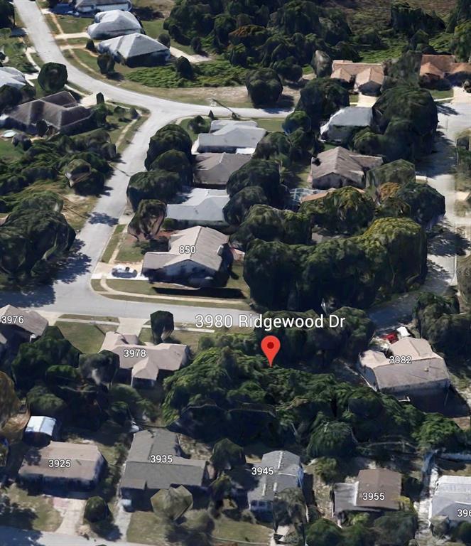 This is an aerial view of a suburban neighborhood showing houses and tree-covered lots — 3980 RIDGEWOOD DRIVE, TITUSVILLE, FL
