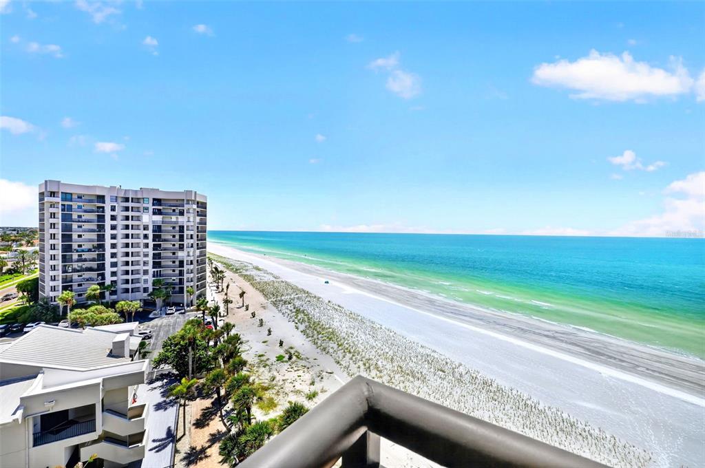 An elevated view of a beach, ocean, and a high-rise building from a balcony — 1600 GULF BOULEVARD UNIT 911, CLEARWATER BEACH, FL