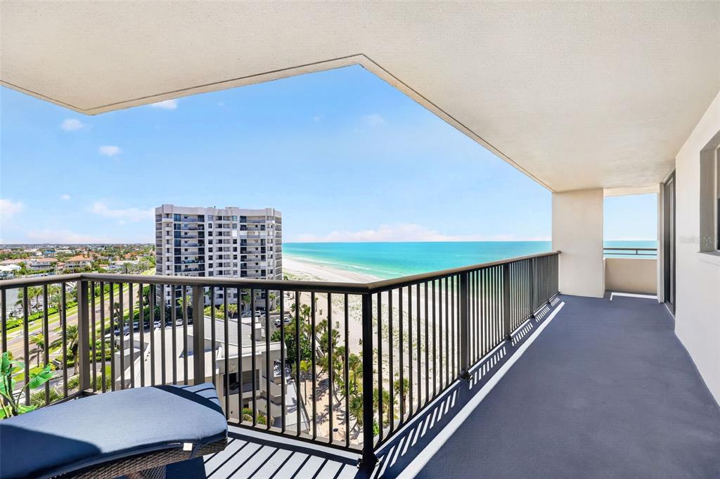 A high-rise balcony features a black metal railing overlooking a beach and the ocean — 1600 GULF BOULEVARD UNIT 911, CLEARWATER BEACH, FL