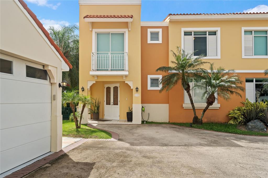 A two-story house with a yellow and orange facade, a front balcony, and a garage — 26 FLAMBOYAN GREENS, HUMACAO, PR