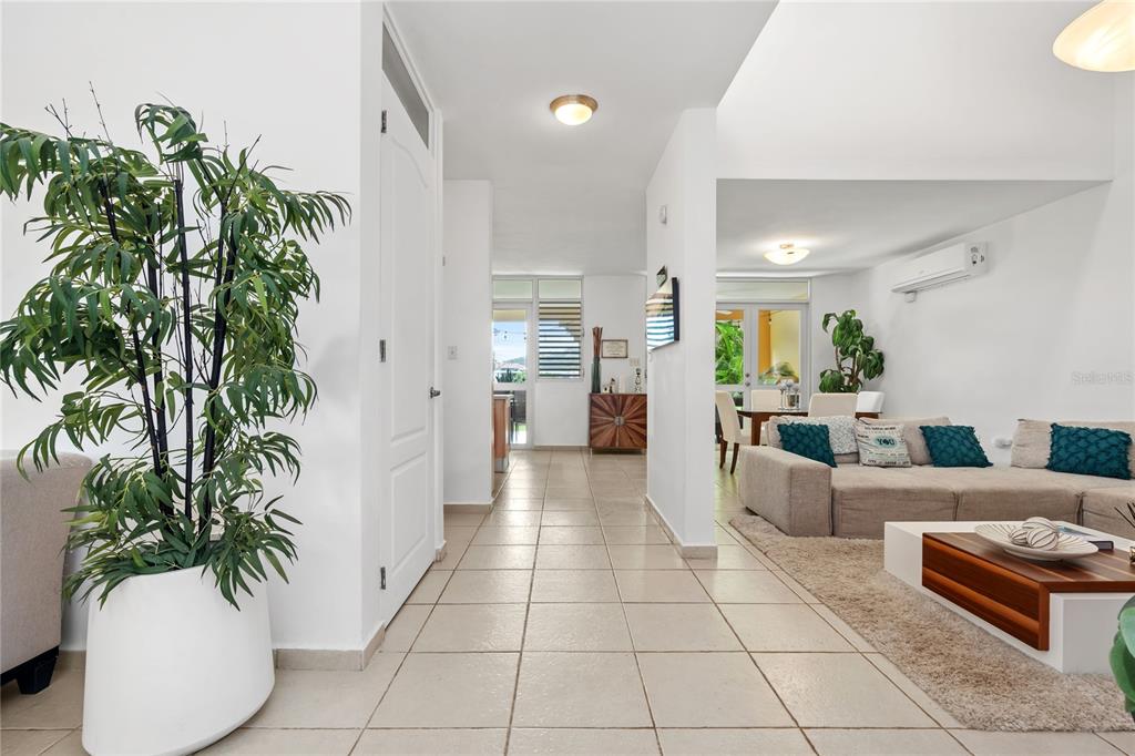 A tiled hallway leads to a living room with a sofa and dining area — 26 FLAMBOYAN GREENS, HUMACAO, PR
