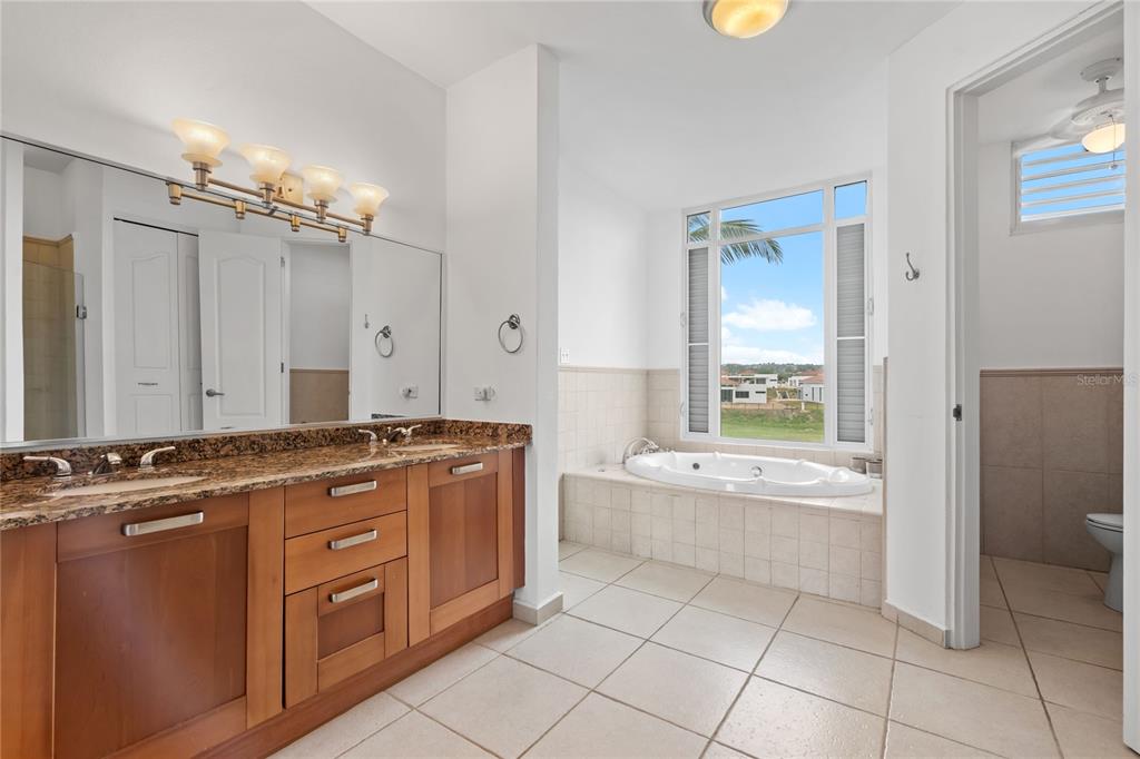 A bathroom with a double vanity, granite countertops, a jetted tub, and tiled flooring — 26 FLAMBOYAN GREENS, HUMACAO, PR