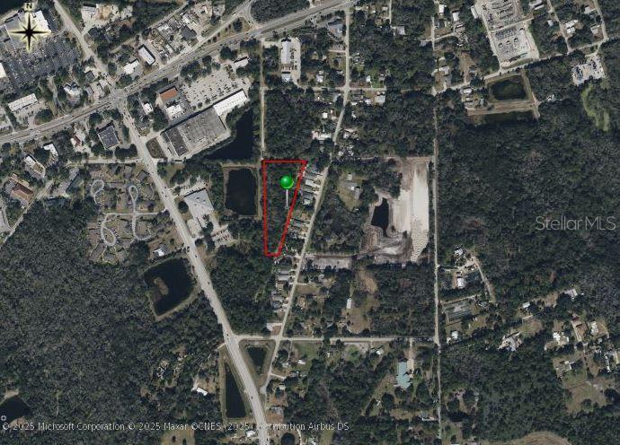 An aerial map shows a vacant, triangular-shaped lot outlined in red with a green marker — SAINT JAMES WAY, NEW SMYRNA BEACH, FL