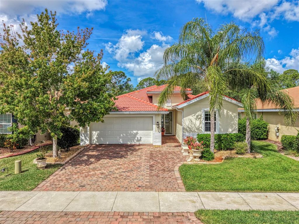 A one-story house with a red tile roof, brick driveway, and a palm tree — 11455 BLACKFIN STREET, VENICE, FL