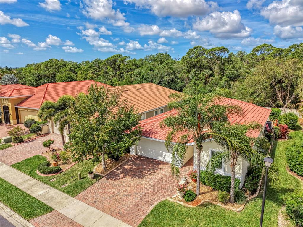 An aerial view shows a single-story house with a red tile roof and brick driveway — 11455 BLACKFIN STREET, VENICE, FL