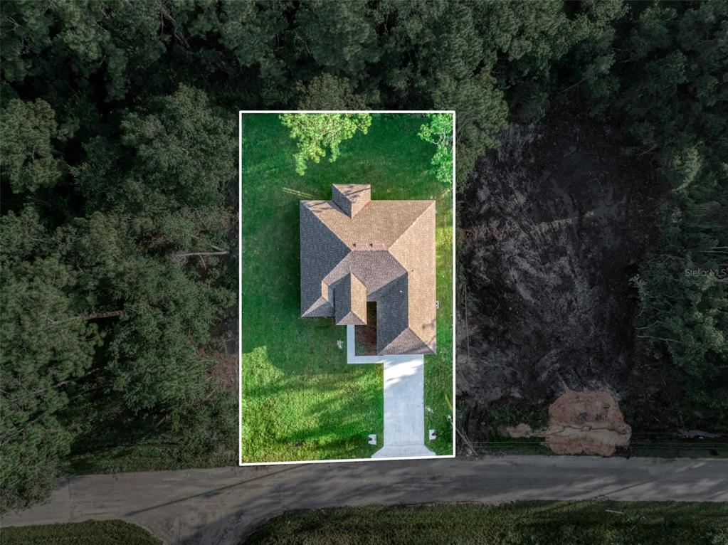 An aerial view shows a house with a shingled roof on a grassy lot — 8381 MANTUA AVENUE, SEBRING, FL