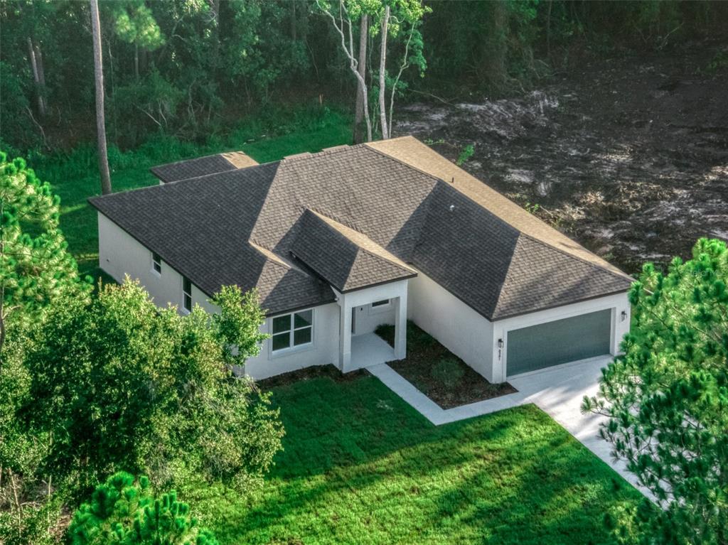 An aerial view of a single-story house with a dark shingled roof and garage — 8381 MANTUA AVENUE, SEBRING, FL
