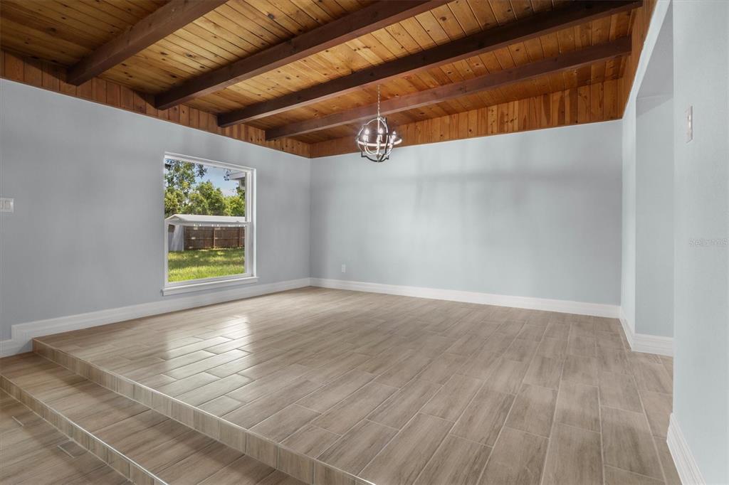 A dining room with a raised floor, wood-plank tile, and a wood-beamed ceiling — 3945 CHART PRINE ROAD, LAKELAND, FL