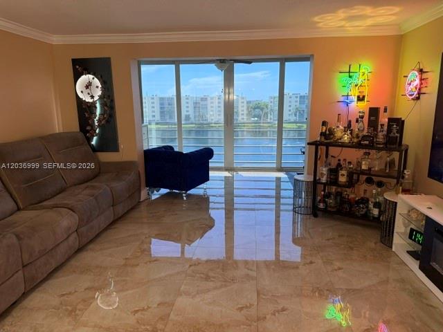 A living room features a brown sofa, a blue armchair, and a bar cart — 101 SE 3rd Ave # 506, Dania Beach FL 33004, DANIA BEACH, FL