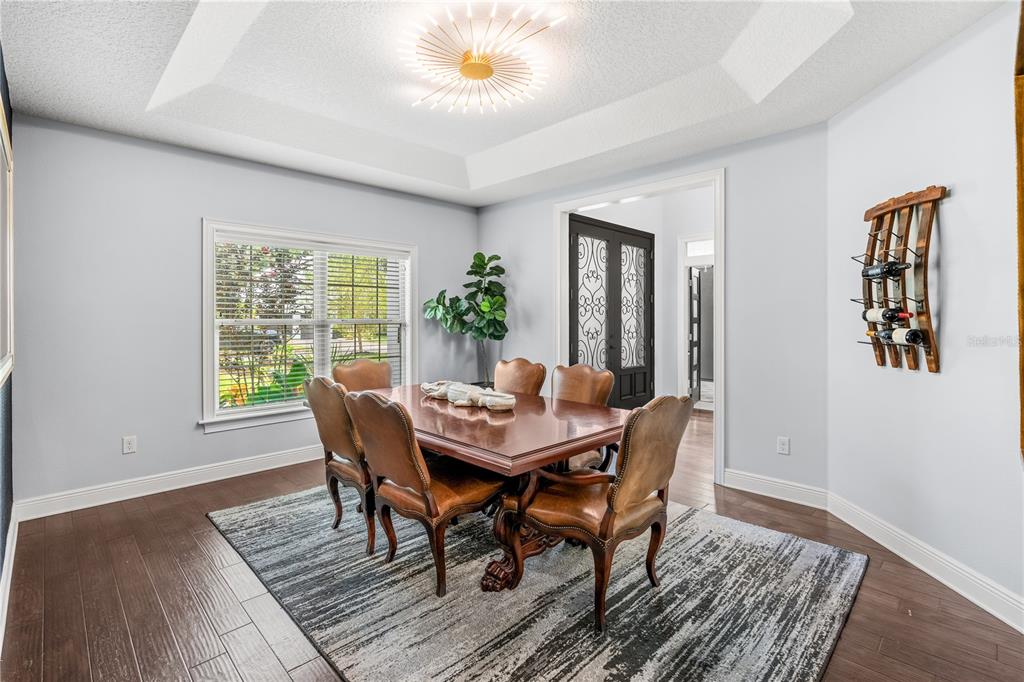 A dining room features a wooden table, leather chairs, a tray ceiling, and hardwood floors — 1840 BRYAN AVENUE, WINTER PARK, FL