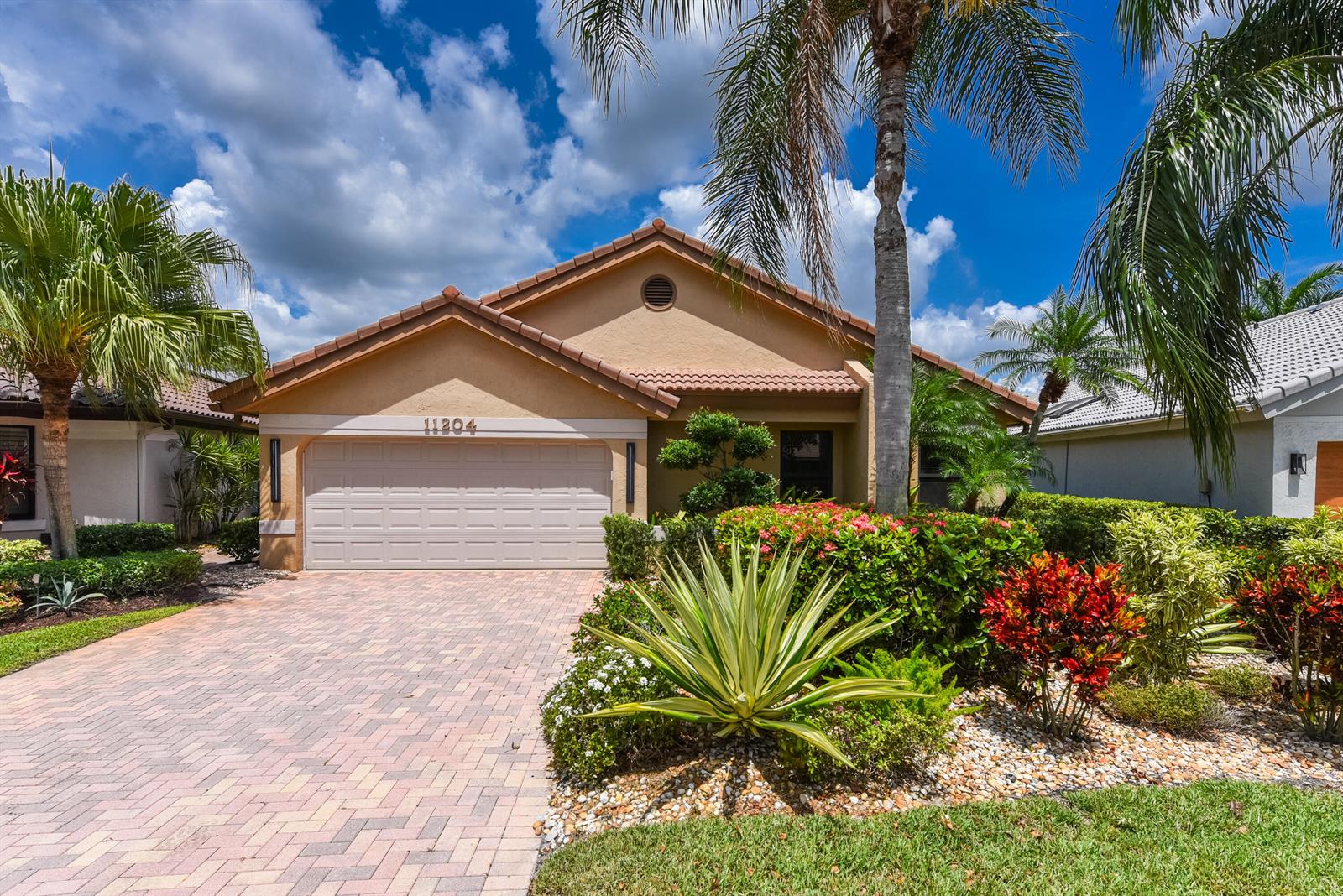 A single-story house with a beige stucco exterior, a tiled roof, and a paved driveway — 11204 Cloverleaf Circle, Boca Raton FL 33428, BOCA RATON, FL