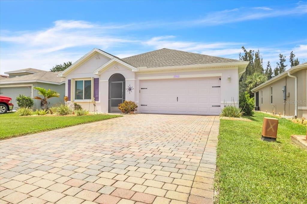 A single-story house with a light-colored exterior, a paved driveway, and a two-car garage — 27932 ARROWHEAD CIRCLE, PUNTA GORDA, FL