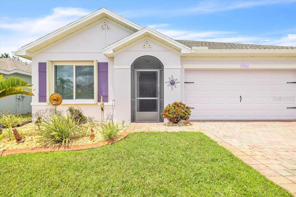 The exterior of a single-story house features a paved driveway, a lawn, and a garage — 27932 ARROWHEAD CIRCLE, PUNTA GORDA, FL