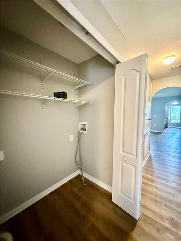 A laundry closet with wire shelving and water hookups features light gray walls and flooring — 4505 ASHBURN SQUARE DRIVE, TAMPA, FL
