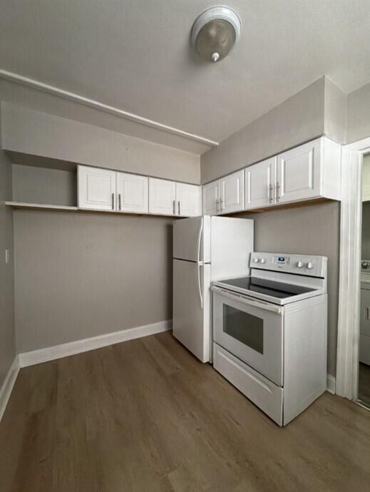 A kitchen features white cabinets, a white refrigerator, a white stove, and light wood flooring — 240 NW 38th Avenue, Lauderhill FL 33311, LAUDERHILL, FL