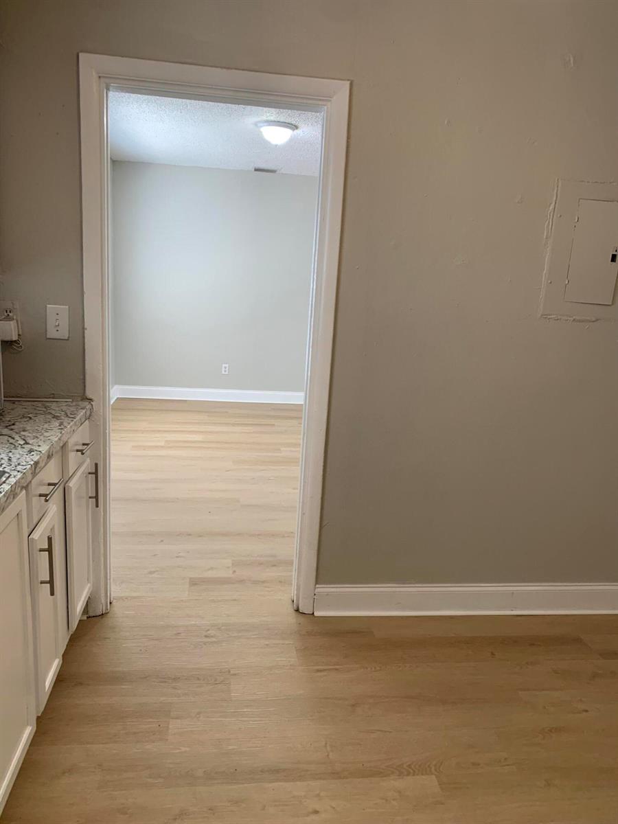 A view from a kitchen with white cabinets into an adjacent room with light flooring — 240 NW 38th Avenue, Lauderhill FL 33311, LAUDERHILL, FL