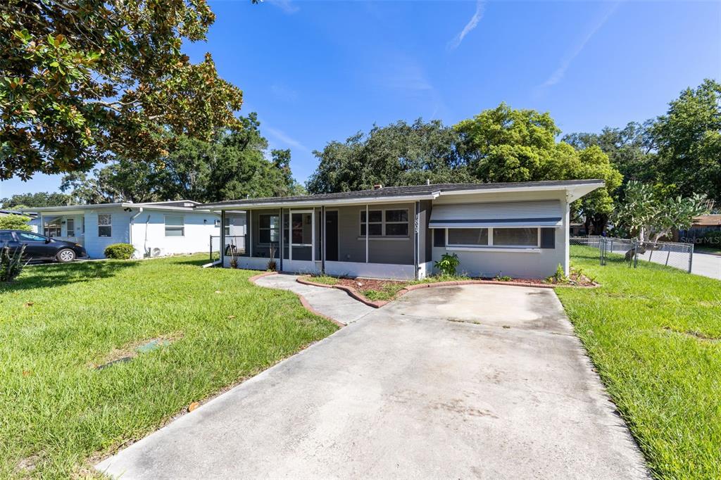 A single-story house with a concrete driveway, a front porch, and a grassy yard — 1805 VERONA STREET, KISSIMMEE, FL