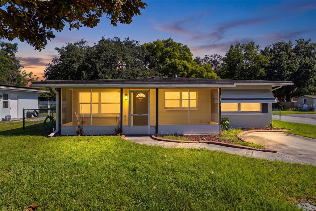A single-story house with a screened-in front porch and a concrete driveway — 1805 VERONA STREET, KISSIMMEE, FL