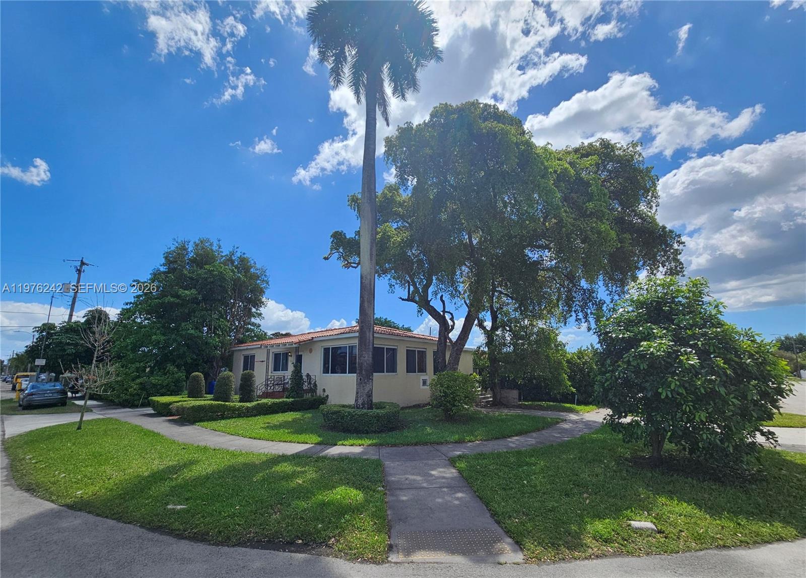 A single-story house with a tile roof sits on a corner lot with mature trees — 3560 NW 19th St, Miami FL 33125, MIAMI, FL