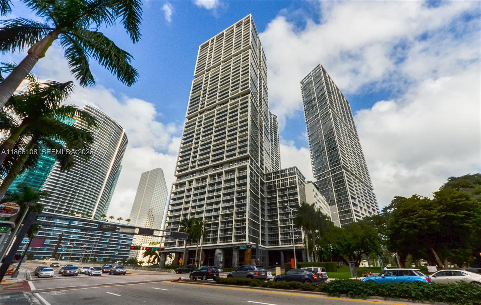 A low-angle exterior view of several modern high-rise apartment buildings in a city — 495 Brickell Ave # 3504, Miami FL 33131, MIAMI, FL