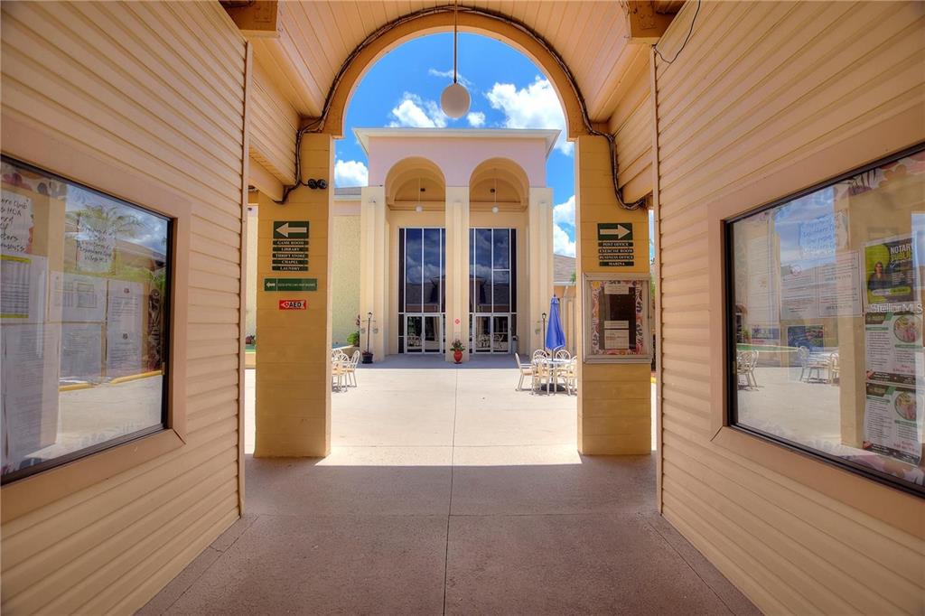 An outdoor covered walkway leads to a courtyard entrance with a large arched opening — 500 CLUB CIRCLE UNIT M, LAKESHORE, FL