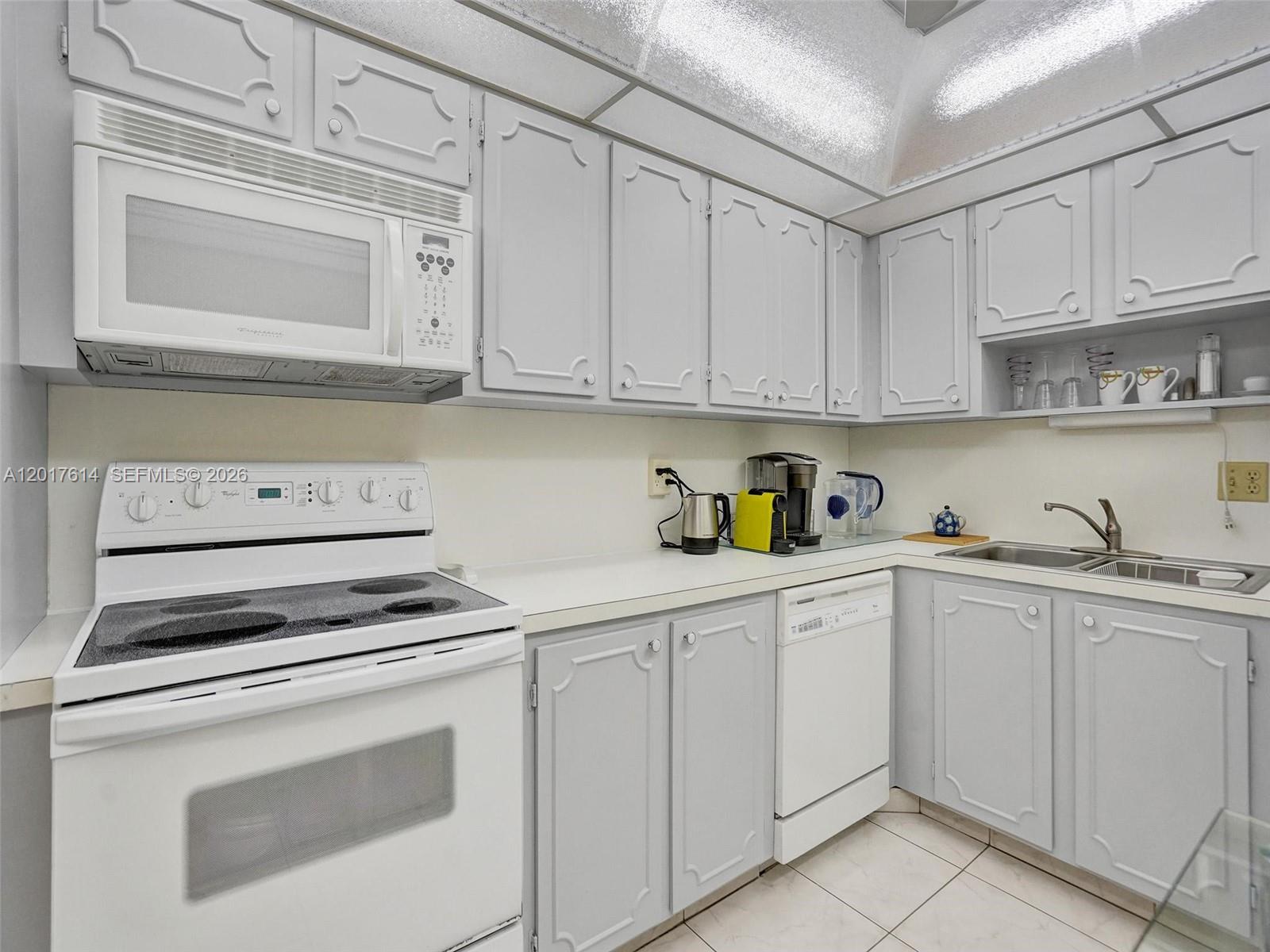 A kitchen features white appliances, light gray cabinets, and a white tiled floor — 3113 S Ocean Dr # 603, Hallandale Beach FL 33009, HALLANDALE BEACH, FL