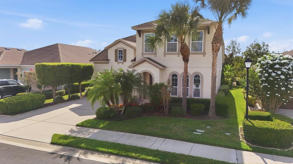 A two-story beige house with a palm tree in the front yard and a driveway — 843 MOLLY CIRCLE, SARASOTA, FL